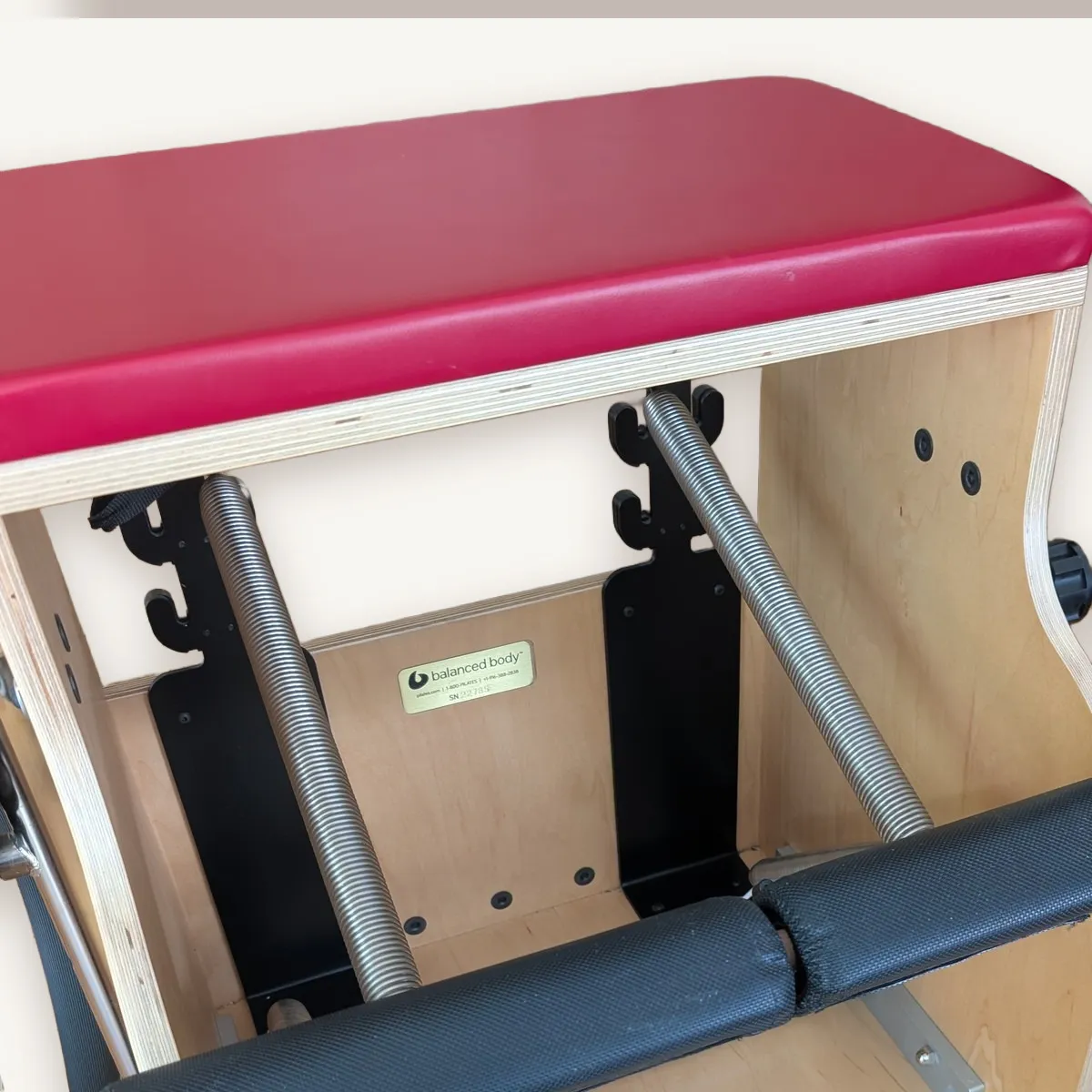 The Pilates chair with its red seat and springs.